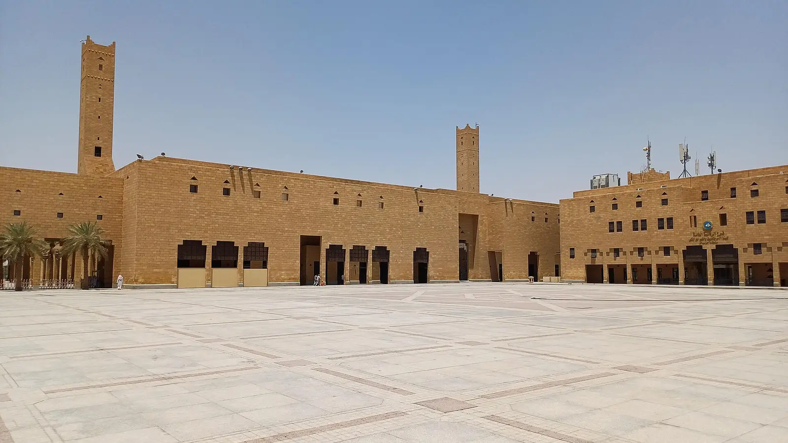 ساحة الديرة في وسط الرياض بمسجد الإمام تركي بن عبدالله بطراز نجدي تقليدي ومئذنتين طينيتين، ساحة عامة فارغة تقريبًا بلا وجوه واضحة أو لافتات تجارية