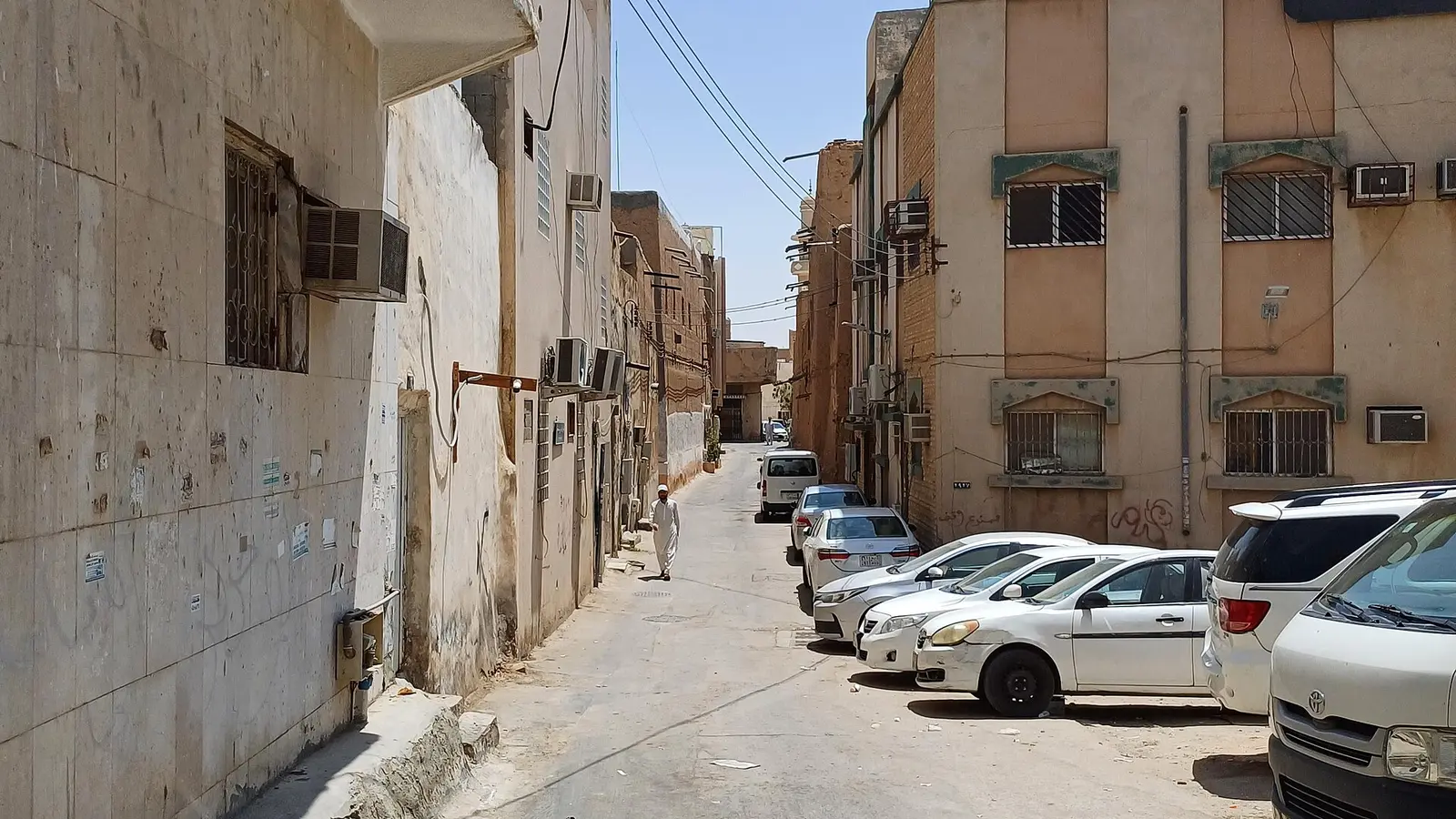 زقاق سكني بمبانٍ سكنية متعددة الطوابق في حي الديرة بالرياض، تمثّل عقارات تُؤجَّر سكنيًا