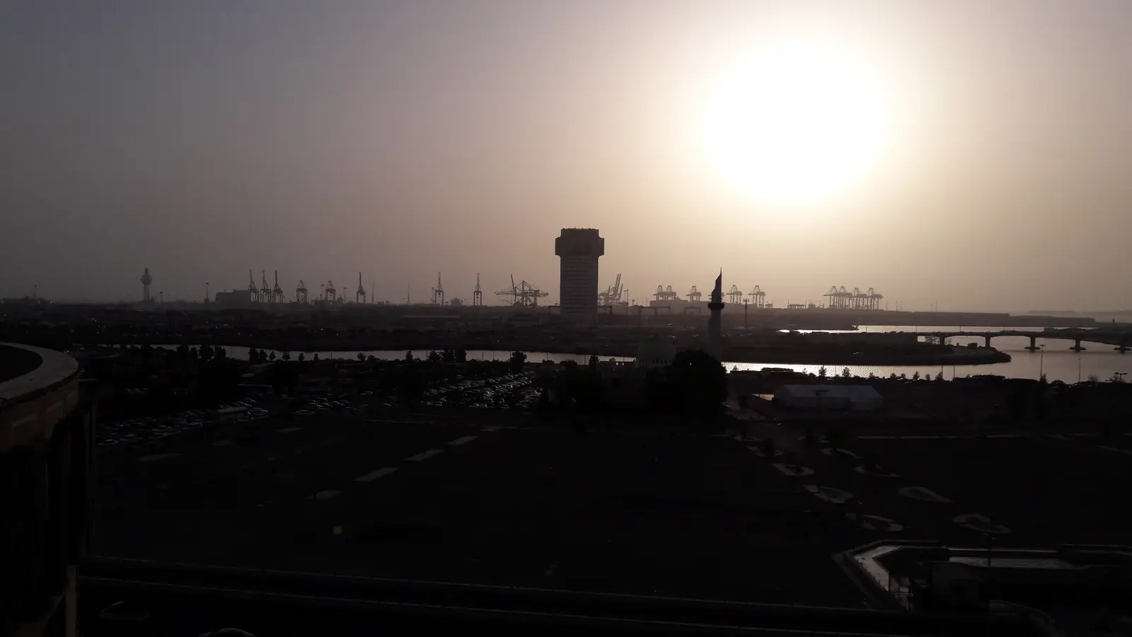 ميناء جدة الإسلامي عند الغروب بأوناش الحاويات وبرج المراقبة، حيث تبدأ إجراءات التخليص الجمركي للبضائع الواردة