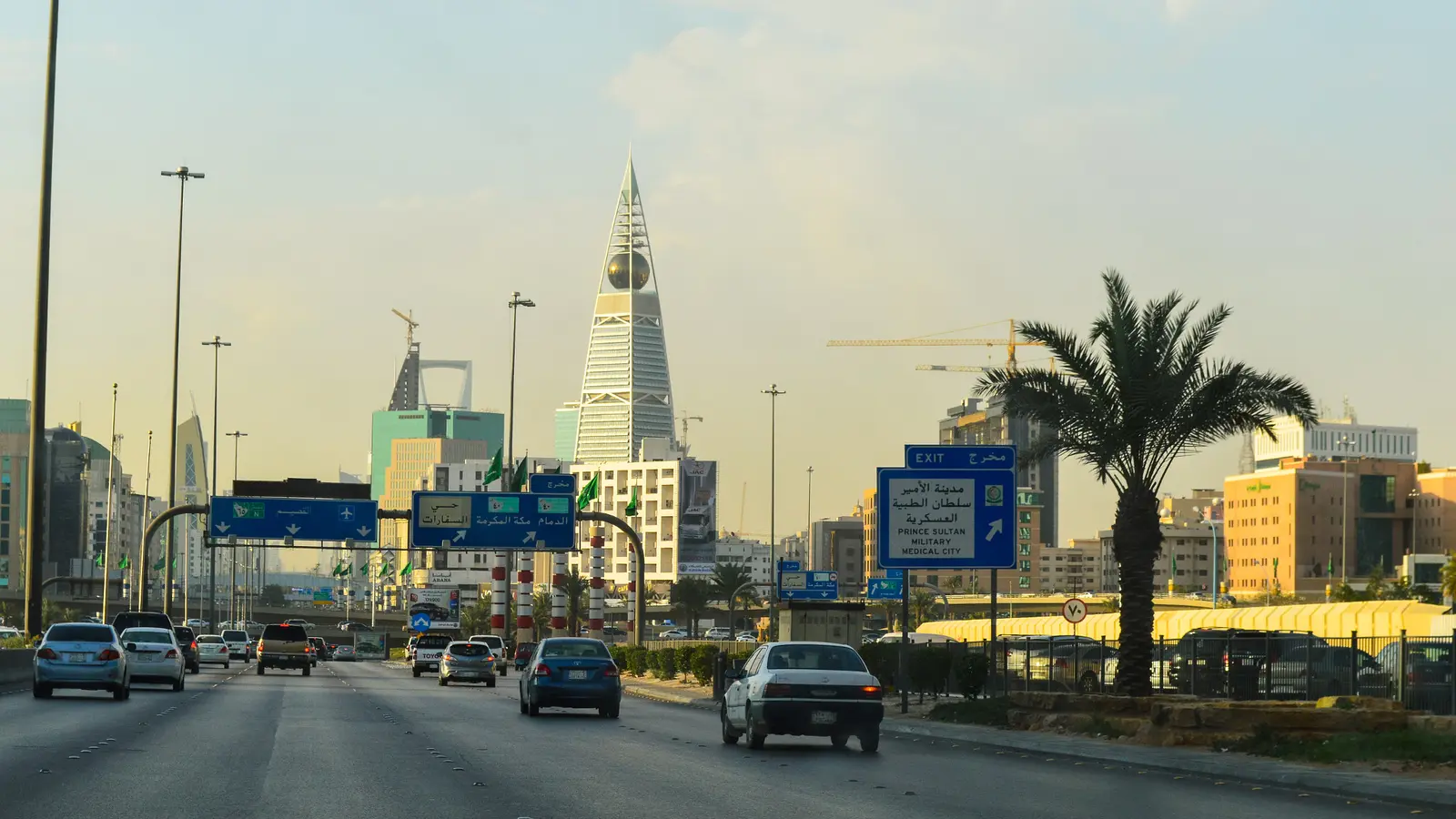 حركة المركبات على طريق الملك فهد في الرياض مع اللوحات الإرشادية، في مشهد يمثّل المركبات الخاضعة لأنظمة المرور والفحص الفني الدوري