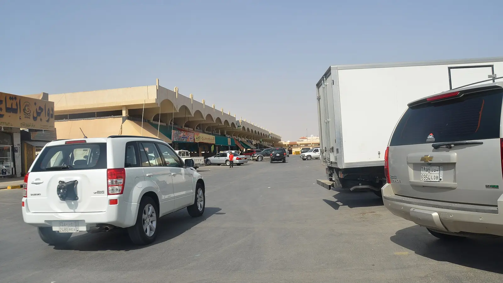 واجهة مبنى السوق المركزي في الرياض وساحة انتظار بها شاحنة توزيع بضائع أمام المحال