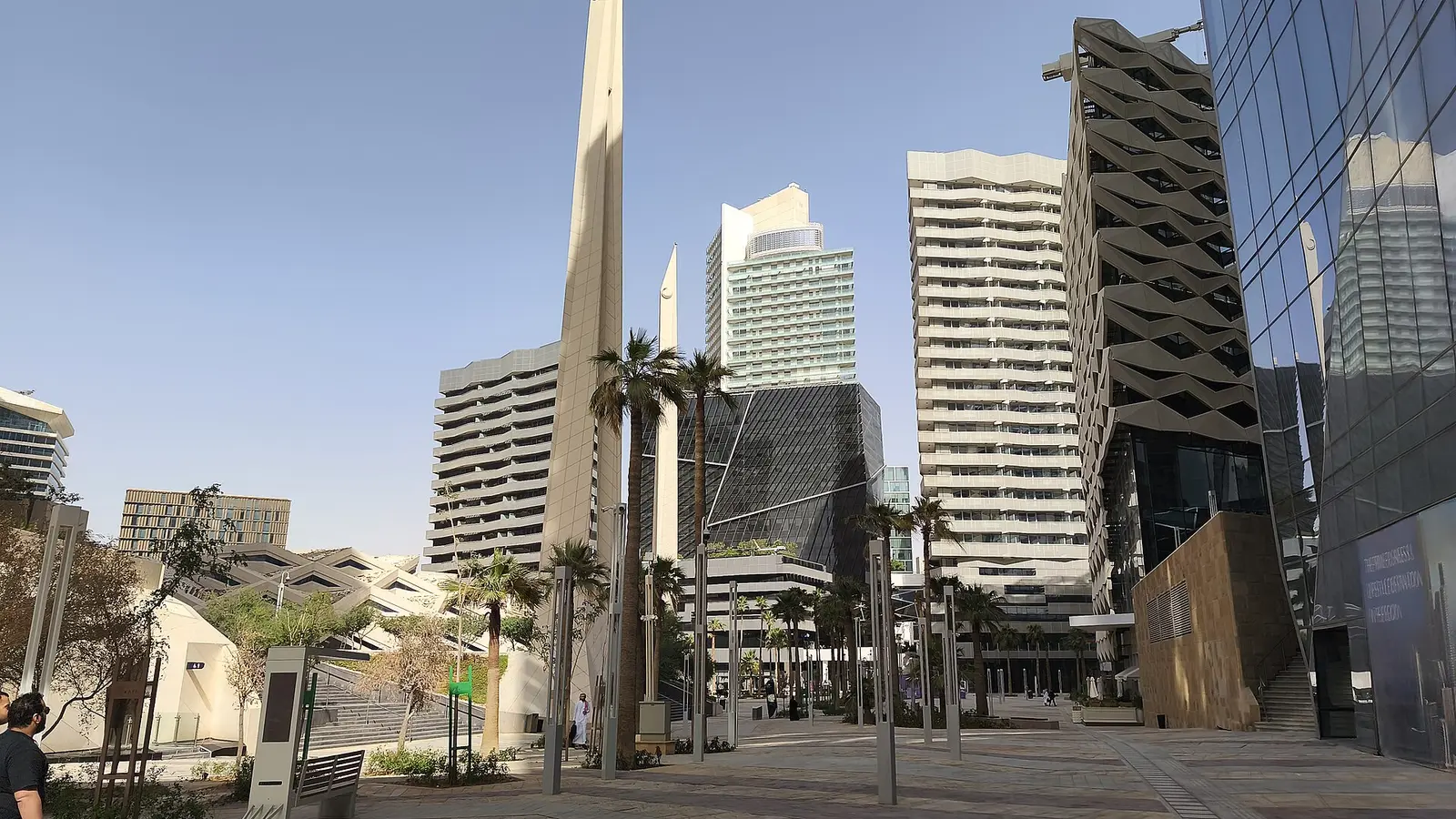 ساحة مشاة بين أبراج مكتبية في مركز الملك عبدالله المالي بالرياض، ترمز إلى بيئة الأعمال التي يسجّل فيها المستثمر الأجنبي نشاطه