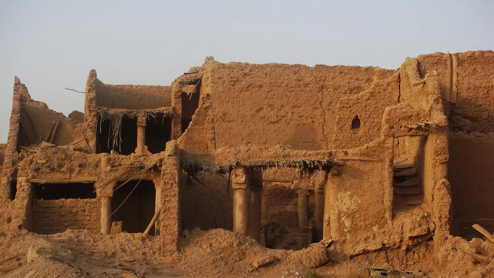 مبنى طيني قديم متصدّع الجدران ومنهار السقف في مجمعة بالقصيم، يمثّل حالة مبنى قائم يحتاج تصحيح وضعه الإنشائي رسميًا