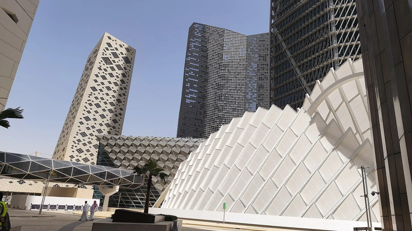 واجهة مبنى بتصميم هندسي مثلث متكرر في مركز الملك عبدالله المالي KAFD بالرياض، وخلفه أبراج زجاجية شاهقة، تعبيرًا عن بيئة الأعمال والاستثمار الأجنبي في السعودية