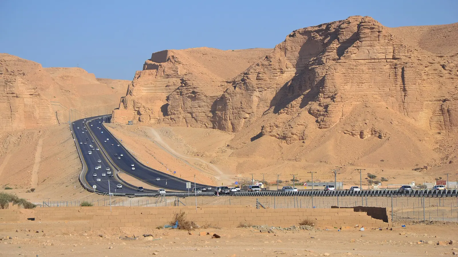 طريق سريع يخترق منطقة جبلية في المملكة العربية السعودية، وعليه حركة مرور للمركبات