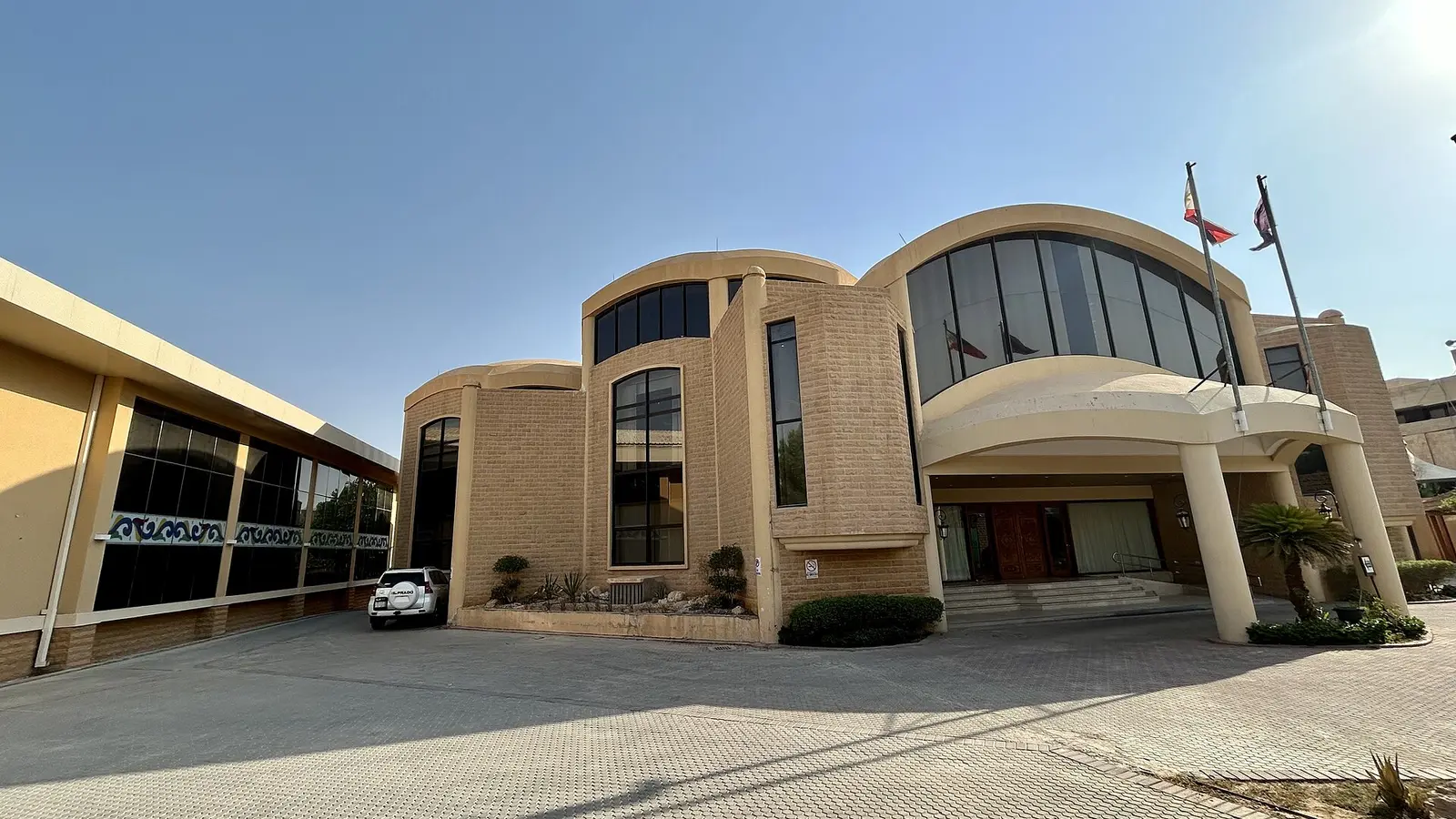مبنى سفارة أجنبية في الرياض بواجهته الحجرية وأعلامه، مثال على البعثات الأجنبية بالمملكة التي تُقدَّم لها توصية وزارة الخارجية